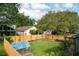 Backyard showcasing lush greenery, a greenhouse, garden beds, and mature trees at 9400 Southern Garden Cir, Altamonte Springs, FL 32714