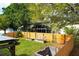 Backyard oasis featuring a wooden fence, lush greenery, a greenhouse, and garden beds at 9400 Southern Garden Cir, Altamonte Springs, FL 32714