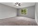 Spacious bedroom featuring a ceiling fan, gray walls, and a window overlooking the yard at 9400 Southern Garden Cir, Altamonte Springs, FL 32714