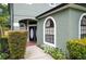 Charming entryway featuring an arched doorway, blooming landscaping, and a welcoming walkway at 9400 Southern Garden Cir, Altamonte Springs, FL 32714