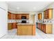 Well-lit kitchen with granite countertops, island, wood cabinets, and tile flooring at 9400 Southern Garden Cir, Altamonte Springs, FL 32714