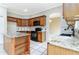 Well-lit kitchen featuring granite countertops, island, wood cabinets, and stainless steel appliances at 9400 Southern Garden Cir, Altamonte Springs, FL 32714