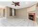 Light-filled living room featuring tile flooring, a ceiling fan, a fireplace, and neutral color palette at 9400 Southern Garden Cir, Altamonte Springs, FL 32714