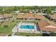 Aerial view of the community pool with lounge chairs, and nearby single-story homes with landscaped yards at 1001 Plantation Dr # D5, Kissimmee, FL 34741