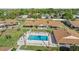 Aerial view of the community pool with lounge chairs, and nearby single-story homes with landscaped yards at 1001 Plantation Dr # D5, Kissimmee, FL 34741