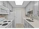 Bright kitchen with grey cabinetry, white appliances, and quartz countertops at 1001 Plantation Dr # D5, Kissimmee, FL 34741