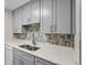 Close up of the kitchen's quartz countertop and tile backsplash at 1001 Plantation Dr # D5, Kissimmee, FL 34741