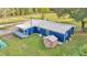 Aerial view showing the home's metal roof, painted exterior, and storage shed, plus a grassy lawn at 10115 E Highway 316, Fort Mc Coy, FL 32134