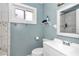 Bathroom with a vanity, toilet, and a tub-shower featuring marble-look tiling and a window at 10115 E Highway 316, Fort Mc Coy, FL 32134