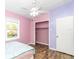 This pink bedroom features wood-look floors and a closet at 10115 E Highway 316, Fort Mc Coy, FL 32134