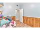 Bedroom with blue walls, wood trim, wood-look floor and an open doorway with a white door at 10115 E Highway 316, Fort Mc Coy, FL 32134