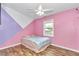 This pink bedroom has an interesting paint design, wood-look floors, and a ceiling fan at 10115 E Highway 316, Fort Mc Coy, FL 32134
