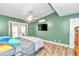 Bedroom with wood-look flooring, tv, ceiling fan, and access to outdoor area at 10115 E Highway 316, Fort Mc Coy, FL 32134
