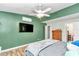 This bedroom features green walls, wood-look floors, a ceiling fan, and a wall-mounted TV at 10115 E Highway 316, Fort Mc Coy, FL 32134