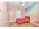 This pink bedroom features wood-look floors and colorful, wavy wall decorations at 10115 E Highway 316, Fort Mc Coy, FL 32134