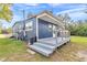 Exterior of blue house with a deck, stairs, green grass, and trees in the background at 10115 E Highway 316, Fort Mc Coy, FL 32134
