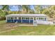 Close up exterior of a blue house, showcasing large windows and a ramp for easy accessibility at 10115 E Highway 316, Fort Mc Coy, FL 32134