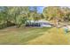 A single-story blue home sits on a spacious green lawn with mature trees and a metal roof at 10115 E Highway 316, Fort Mc Coy, FL 32134