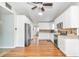 Bright kitchen with white cabinets, stainless steel appliances, wood look floors, and tile backsplash at 10115 E Highway 316, Fort Mc Coy, FL 32134
