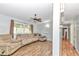 Comfortable living room with a large window, hardwood floors, fan, and light gray paint at 10115 E Highway 316, Fort Mc Coy, FL 32134