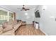 Spacious living room featuring wood-look flooring, ceiling fan, neutral paint, and TV at 10115 E Highway 316, Fort Mc Coy, FL 32134