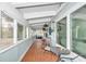 Enclosed porch featuring wood floors, ample seating, natural light, and serene views at 10115 E Highway 316, Fort Mc Coy, FL 32134