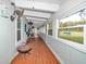Enclosed porch with red wood floor and walls of windows overlooking a large yard at 10115 E Highway 316, Fort Mc Coy, FL 32134