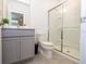 Modern bathroom with gray vanity, toilet, and glass-enclosed shower, offering a clean, contemporary design at 10443 Ebb Tide Ln, Orlando, FL 32821