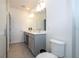 This bathroom features double sinks, gray cabinets, quartz countertops and a glass shower at 10443 Ebb Tide Ln, Orlando, FL 32821