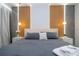 This bedroom features a gray comforter, wood accent wall, stylish light fixture, and nightstands at 10443 Ebb Tide Ln, Orlando, FL 32821