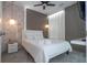 This bedroom features white bedding, unique light fixture, accent wall, and ceiling fan at 10443 Ebb Tide Ln, Orlando, FL 32821