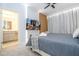 This bedroom features a gray comforter, wood accent wall, TV, ceiling fan and an attached bathroom at 10443 Ebb Tide Ln, Orlando, FL 32821