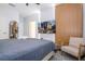 This bedroom features a gray comforter, wood accent wall, TV, beige armchair, and ceiling fan at 10443 Ebb Tide Ln, Orlando, FL 32821