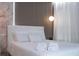 This bedroom features white bedding, accent wall, stylish light fixture, and accent plant at 10443 Ebb Tide Ln, Orlando, FL 32821