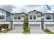 Charming townhomes with two-car garages, and a light gray brick driveway at 10443 Ebb Tide Ln, Orlando, FL 32821