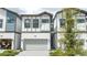 A white townhouse with a gray trim, a one car garage, and a gray stone driveway at 10443 Ebb Tide Ln, Orlando, FL 32821