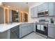 Beautiful modern kitchen features stainless steel appliances and stylish gray cabinetry, and an island with barstool seating at 10443 Ebb Tide Ln, Orlando, FL 32821