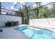 Inviting screened-in pool area features a spa, and an outdoor dining set for relaxation and entertainment at 10443 Ebb Tide Ln, Orlando, FL 32821