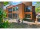 A view of the backyard that features a screened patio, stairs and mature trees at 1068 E Michigan St # A, Orlando, FL 32806