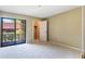Cozy bedroom with plush carpeting, neutral tones, and sliding door to patio at 1068 E Michigan St # A, Orlando, FL 32806