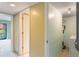 Hallway with a washer and dryer, neutral paint, and access to the back patio at 1068 E Michigan St # A, Orlando, FL 32806
