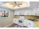 Cozy kitchen featuring white appliances, laminate countertops, wood-look floors and natural light at 1068 E Michigan St # A, Orlando, FL 32806