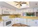 Bright kitchen area with white appliances, laminate counters, and pass through to living area at 1068 E Michigan St # A, Orlando, FL 32806