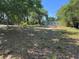 Large, partially shaded backyard with ample space, surrounded by mature trees at 1121 Santa Anita St, Orlando, FL 32808
