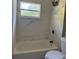 Modern bathroom featuring sleek, white marble-style tiling, a tub, and a new toilet at 1121 Santa Anita St, Orlando, FL 32808