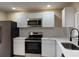 Updated kitchen features white cabinets, stainless steel appliances, and modern countertops at 1121 Santa Anita St, Orlando, FL 32808