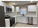 Updated kitchen features stainless steel appliances, white cabinets, and tile flooring at 1121 Santa Anita St, Orlando, FL 32808