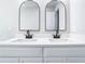 Stylish bathroom featuring double vanity with granite countertop, modern sinks, and arched mirrors at 11364 Cardiff Dr, Orlando, FL 32837