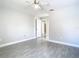Bright and neutral bedroom featuring wood-look tile floors, ceiling fan, and view to hall at 11364 Cardiff Dr, Orlando, FL 32837