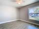 Well-lit bedroom with light gray walls, wood-look tile floors, ceiling fan, and bright window at 11364 Cardiff Dr, Orlando, FL 32837
